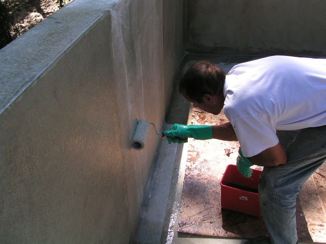 piscine-beton-fibre-de-verre stratification : Application de la résine polyester sur  la fibre de verre posée sur les murs.